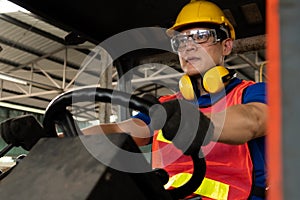 Skillful worker drives forklift in the factory .