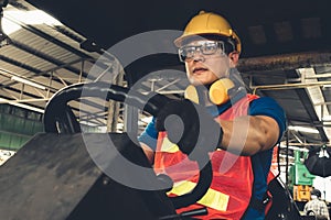 Skillful worker drives forklift in the factory .