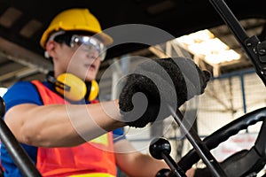 Skillful worker drives forklift in the factory .