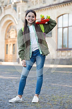 Skills on wheels Happy girl hold penny board autumn outdoors. Sport and leisure. Transport and transportation. Street