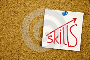 Skills written on sticky note pinned on pinboard Improve Your skills Concept