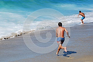 Skim Boarder preparing to ride a shore break wave at Aliso Beach in Laguna Beach, California.