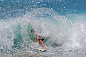 Skim Boarder riding a shore break wave at Aliso Beach in Laguna Beach, California.