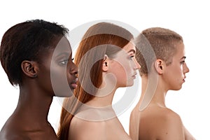 Skin beauty. Portrait of three beautiful multicultural young women in profile. Two caucasian and african half naked