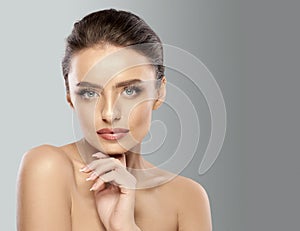 Skin care. Attractive woman with bare shoulders, expressive gray eyes, long eyelashes, full lips, and smooth skin