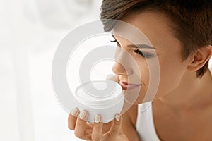 Skin Care. Beautiful Happy Woman Holding Face Cream Lotion