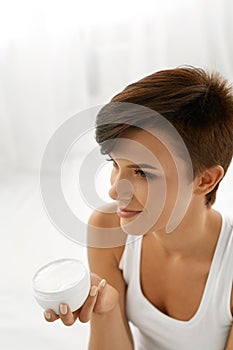 Skin Care. Beautiful Happy Woman Holding Face Cream, Lotion