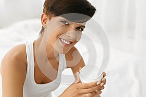 Skin Care. Beautiful Happy Woman Holding Face Cream, Lotion