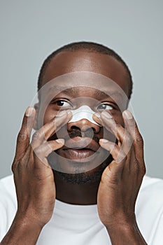 Skin Care. Beauty Treatment Concept. Man Applying White Nose Patch. photo