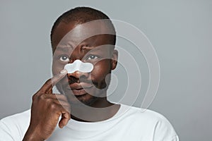 Skin Care. Beauty Treatment Concept. Man Applying White Nose Patch. photo