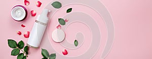 Skin care, body care products, rose leaves and petals, on a pink background. The concept of spa and natural skin care. Top view.