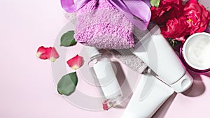 Skin care, body care products, rose leaves and petals, on a pink background. The concept of spa and natural skin care. Top view.