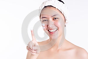 Skin care concept. Asian woman showing cream, apply moisturizer on face. Young woman apply cream, lotion to beauty skin on face in