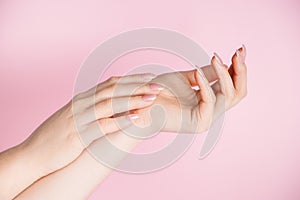 Skin care concept. Beautiful female hands on pink background. Place for text.