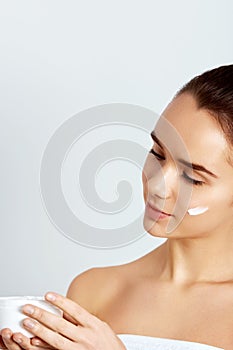 Skin Care Concept. Beautiful Woman Holding Face Cream In Hands. Closeup Portrait Of Model Girl With Natural Nude Makeup,