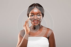 Skin Care Concept. Portrait Of Attractive African American Female Applying Moisturising Cream photo