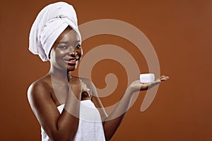 Skin Care Cosmetics. Young beautiful black woman holding jar of moisturising cream