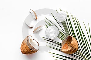 Skin care cream with coconut oil on white background top-down