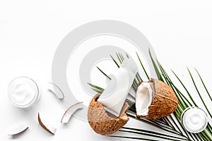 Skin care cream with coconut oil on white background top-down frame copy space