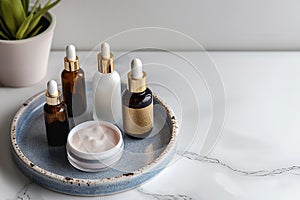 Skin care essence serum bottles with dropper on marble cosmetic tray on light background. Vitamins for skin. Hydrating anti aging