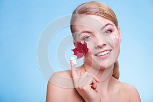 Skin care. Face of young woman girl with red maple leaf.