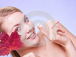 Skin care. Face of young woman girl with red maple leaf.