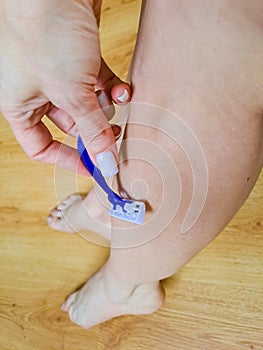 Skin Care and Health. Hair Removal. Fit Woman Shaving Her Legs With Razor.