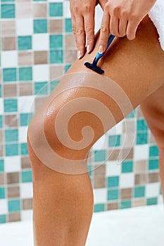 Skin Care and Health. Hair Removal. Fit Woman Shaving Her Legs With Razor. Wet feet, women legs in the shower