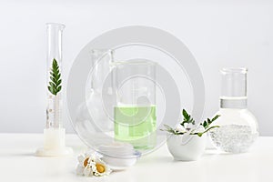 Skin care product, ingredients and laboratory glassware on table.