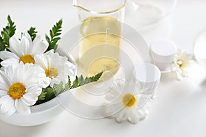 Skin care products, ingredients and laboratory glassware on white background