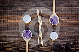 Skin care and relax. Cosmetics and aromatherapy concept. Lavender spa salt on dark wooden background top view