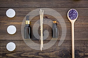 Skin care and relax. Cosmetics and aromatherapy concept. Lavender spa salt and oil on dark wooden background top view