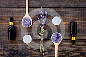 Skin care and relax. Cosmetics and aromatherapy concept. Lavender spa salt and oil on dark wooden background top view