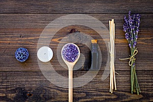 Skin care and relax. Cosmetics and aromatherapy concept. Lavender spa salt and oil on dark wooden background top view