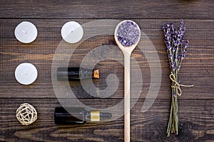 Skin care and relax. Cosmetics and aromatherapy concept. Lavender spa salt and oil on dark wooden background top view