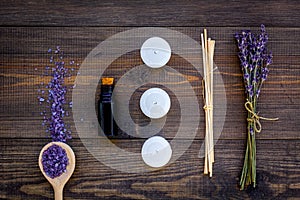 Skin care and relax. Cosmetics and aromatherapy concept. Lavender spa salt and oil on dark wooden background top view