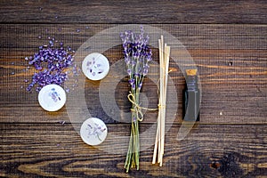 Skin care and relax. Cosmetics and aromatherapy concept. Lavender spa salt and oil on dark wooden background top view