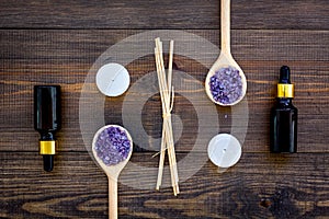 Skin care and relax. Cosmetics and aromatherapy concept. Lavender spa salt and oil on dark wooden background top view