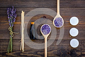 Skin care and relax. Cosmetics and aromatherapy concept. Lavender spa salt and oil on dark wooden background top view