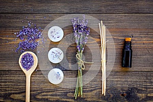 Skin care and relax. Cosmetics and aromatherapy concept. Lavender spa salt and oil on dark wooden background top view
