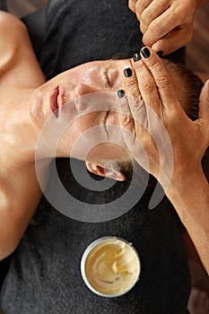Skin Care. Resting Woman On Facial Treatment Procedure. Beautician Applying Face Mask.