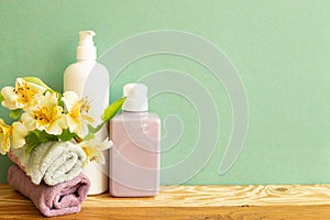 Skin care and spa concept. Bathroom bottles and towel with yellow flowers on wooden shelf