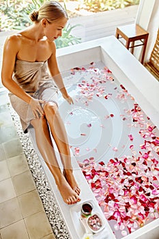 Skin Care Spa Treatment. Woman On Bathtub. Flower Rose Bath.