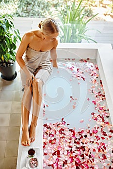 Skin Care Spa Treatment. Woman On Bathtub. Flower Rose Bath.