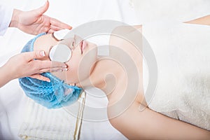 Skin care - woman cleaning face by beautician