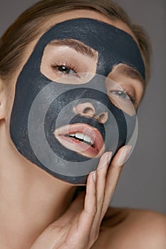 Skin care. Woman face with cosmetic spa clay mask closeup