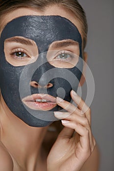 Skin care. Woman face with cosmetic spa clay mask closeup