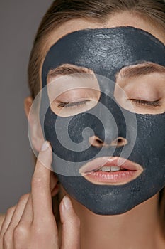 Skin care. Woman face with cosmetic spa clay mask closeup