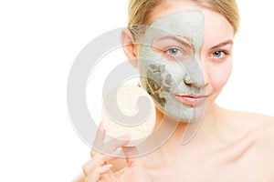 Skin care. Woman removing clay mud facial mask