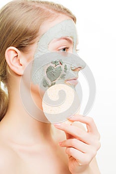 Skin care. Woman removing clay mud facial mask
